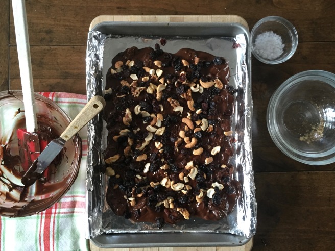 Topping chocolate bark with remaining nuts and fruit.