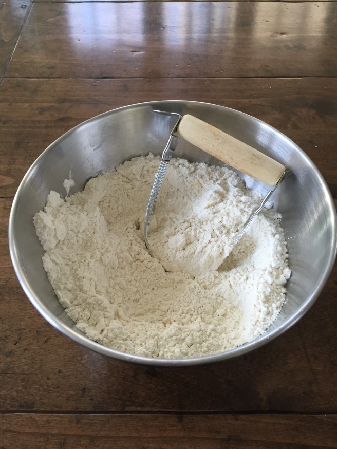 Using a pastry blender to cut butter into flour.