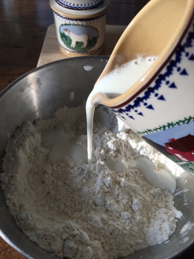 Pouring buttermilk into bowl of dry ingredients.