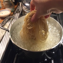 Dropping chinese noodles into boiling water