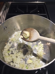 Add smashed garlic to wilted onion in saucepan