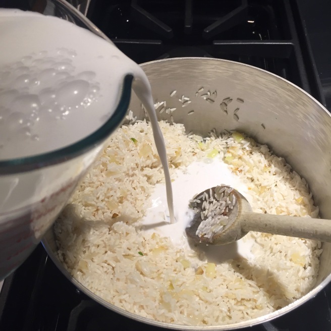 Adding coconut milk/chicken broth mixture to rice