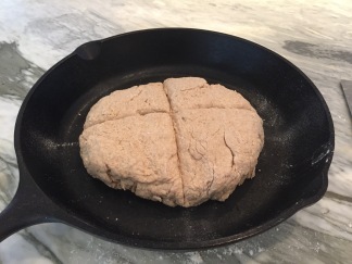 Brown Soda Bread dough cut with deep cross in cast iron skillet